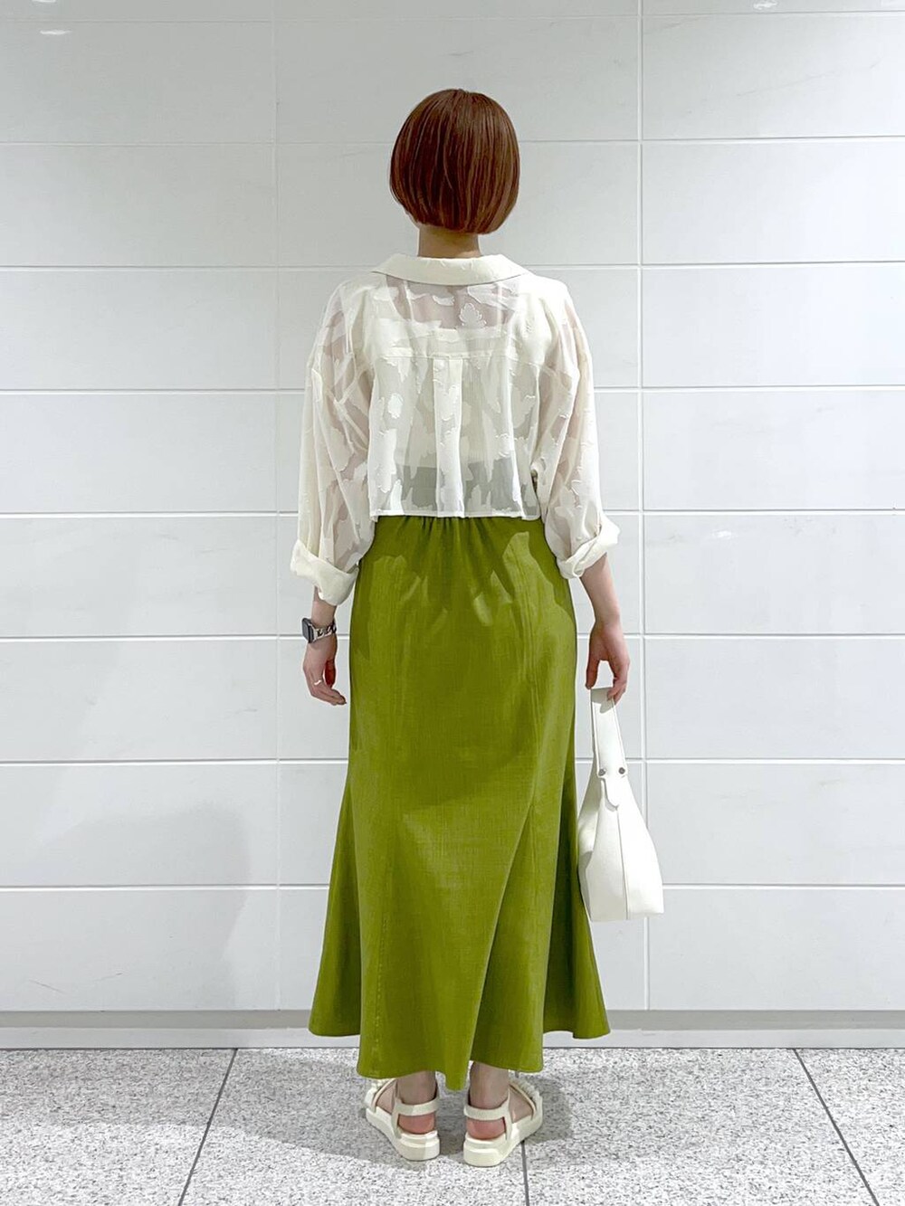 ホワイト系のタンクトップ、グリーン系のスカート、ホワイト系のワンピースを着用したレディースの春コーディネートの3枚目の写真