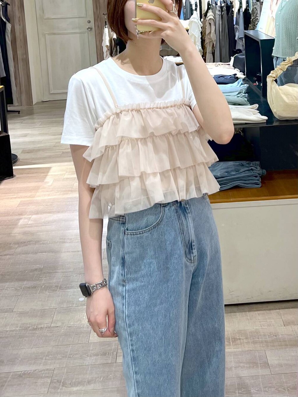 ブルー系のデニムパンツ、ホワイト系のサンダル、シルバー系のショルダーバッグを着用したレディースの夏コーディネートの4枚目の写真