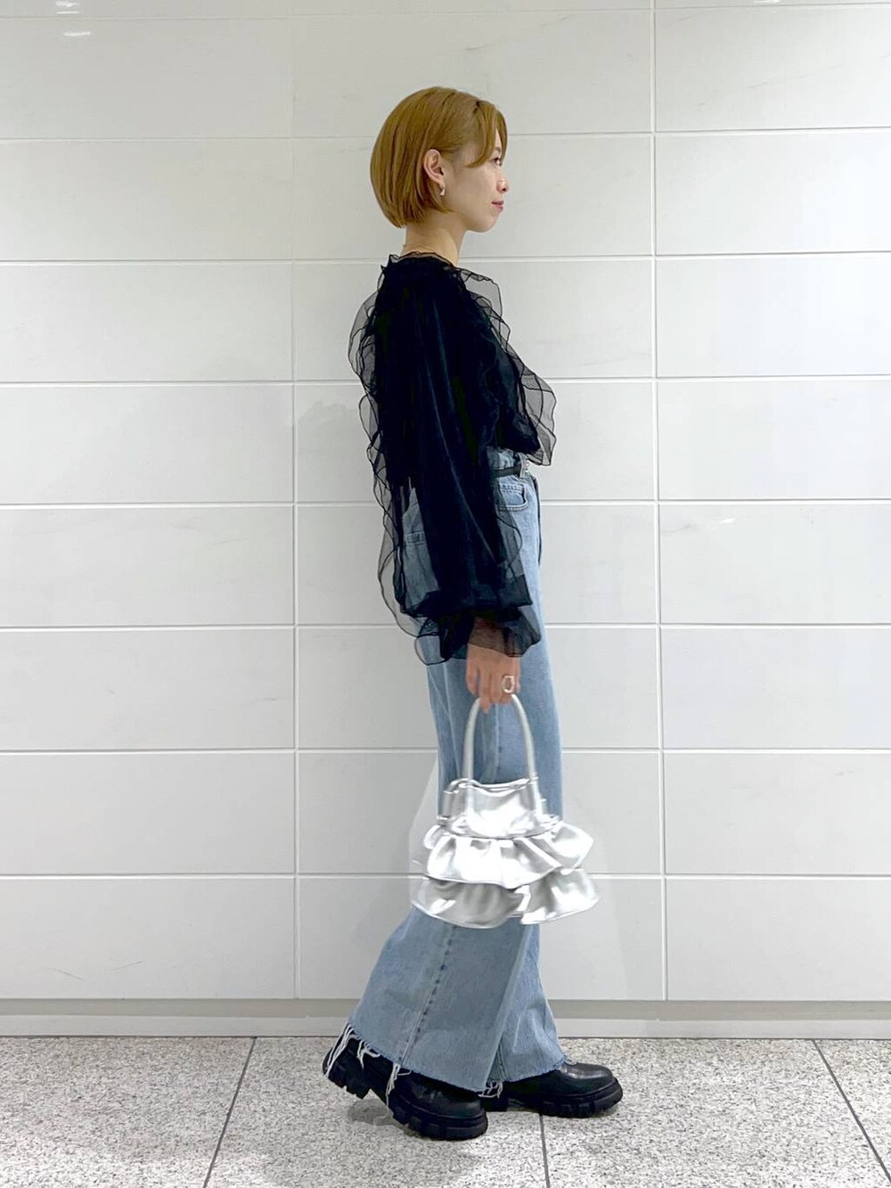 ブルー系のデニムパンツ、シルバー系のショルダーバッグ、ブラック系のシャツ/ブラウスを着用したレディースの秋コーディネートの3枚目の写真