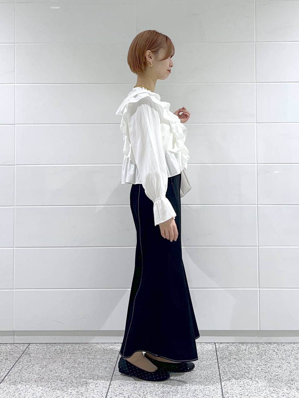 ベージュ系のショルダーバッグ、ホワイト系のシャツ/ブラウス、ブラック系のバレエシューズを着用したレディースの春コーディネートの2枚目の写真