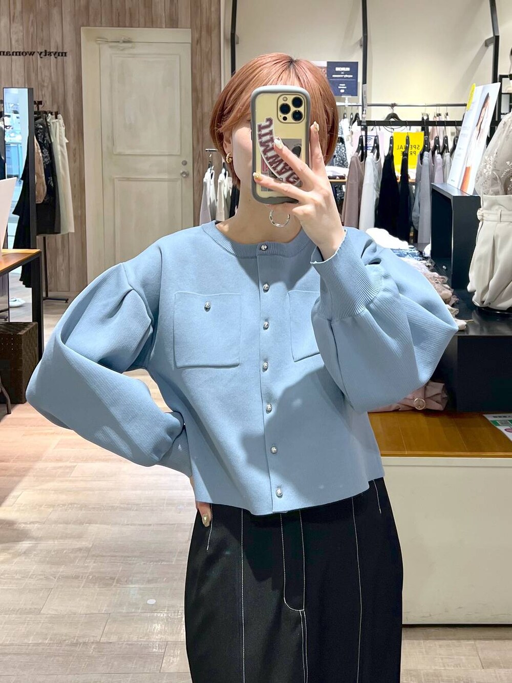 ホワイト系のトートバッグ、ブラック系のパンプス、ブラック系のスカートを着用したレディースの春コーディネートの5枚目の写真