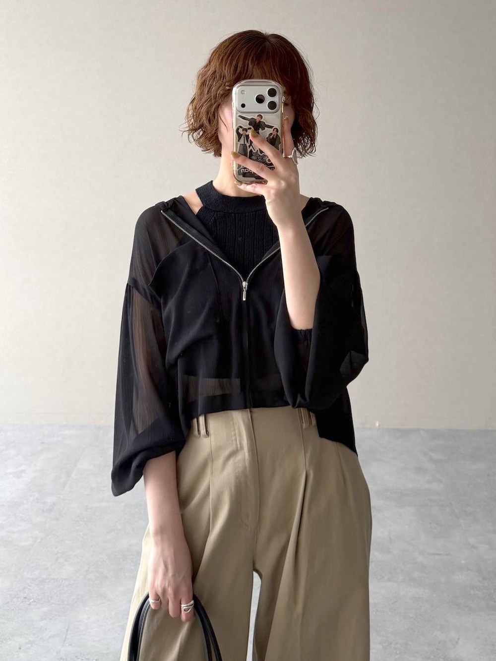 ブラック系のパーカー、ブラック系のサンダル、ブラック系のニット/セーターを着用したレディースの春コーディネートの4枚目の写真