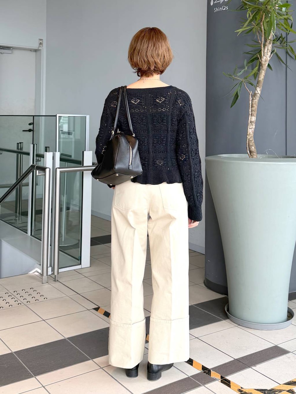 ブラック系のハンドバッグ、ブラック系のローファー、ブラック系のカーディガン/ボレロを着用したレディースの冬コーディネートの3枚目の写真