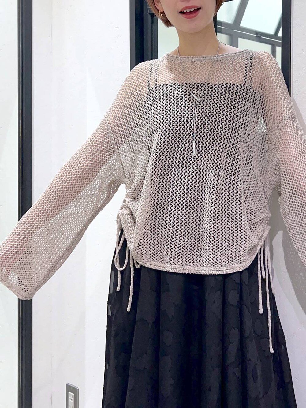 ブラック系のサンダル、ベージュ系のニット/セーター、ブラック系のキャミソールを着用したレディースの春コーディネートの6枚目の写真