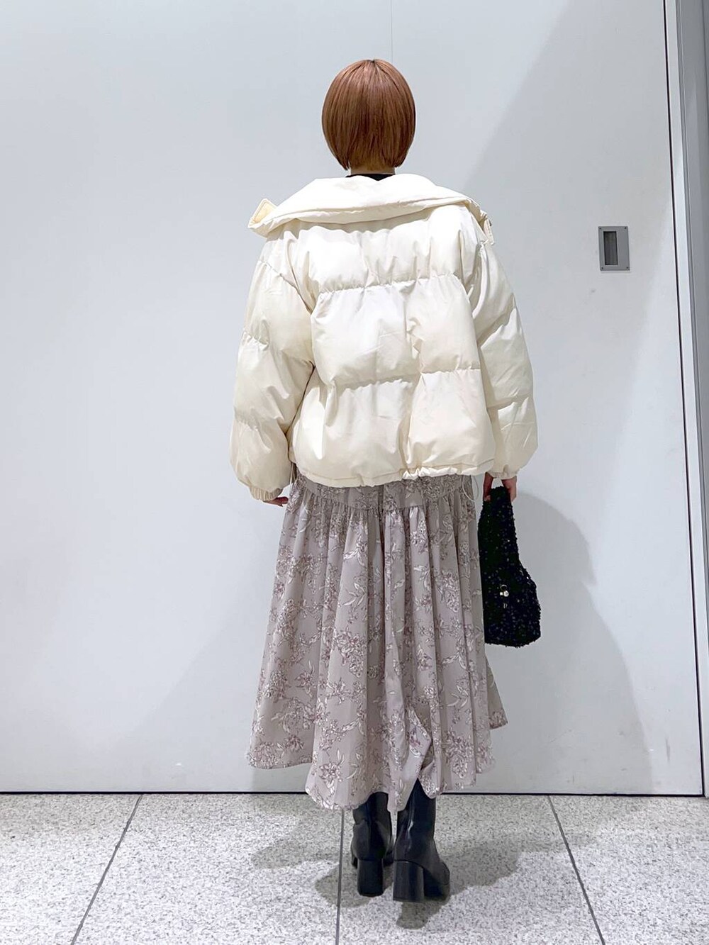 ブラック系のブーツ、ブラック系のニット/セーター、ブラック系のハンドバッグを着用したレディースの冬コーディネートの3枚目の写真