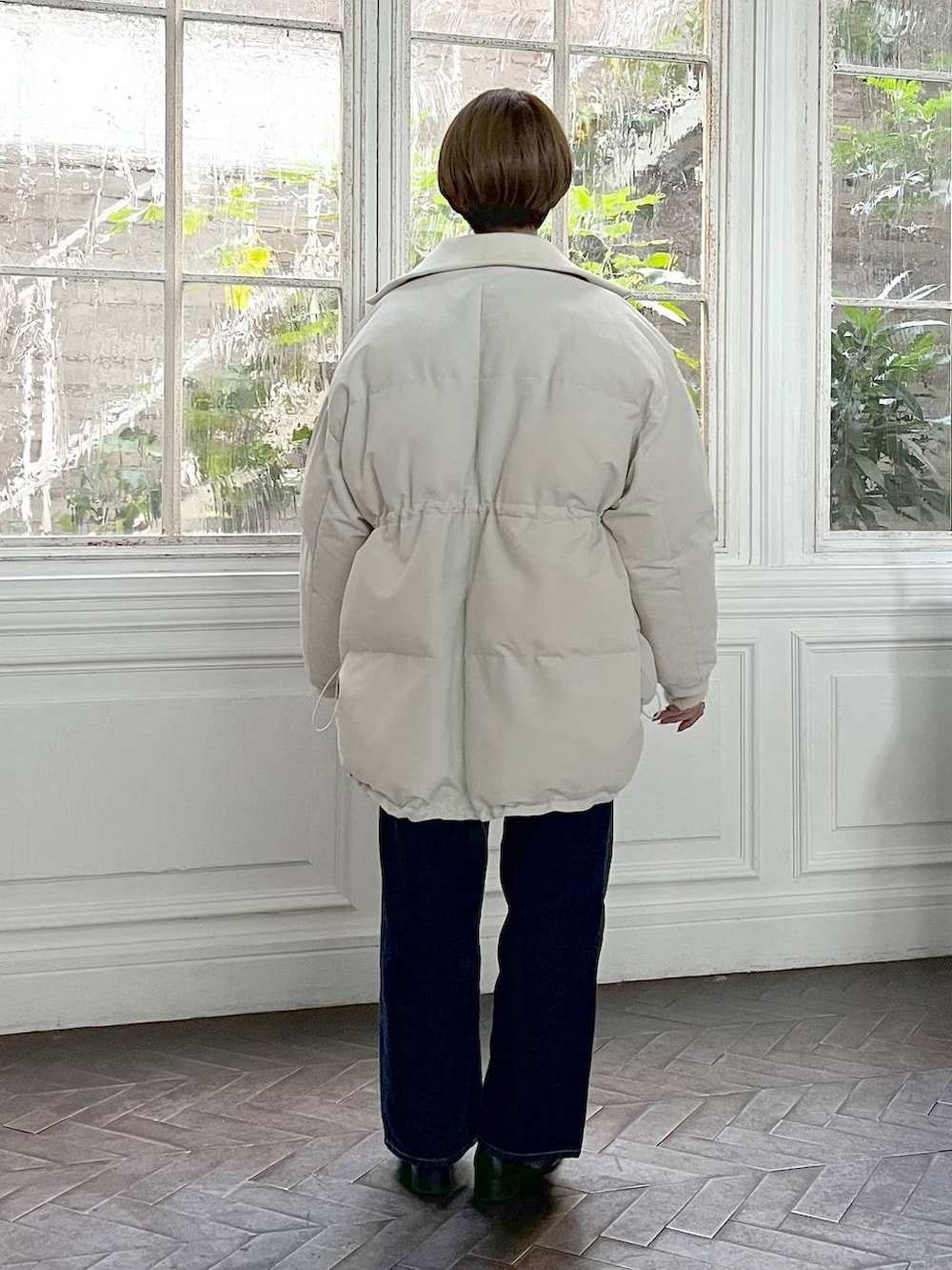 ブルー系のデニムパンツ、ブラック系のローファー、ホワイト系のニット/セーターを着用したレディースの冬コーディネートの3枚目の写真