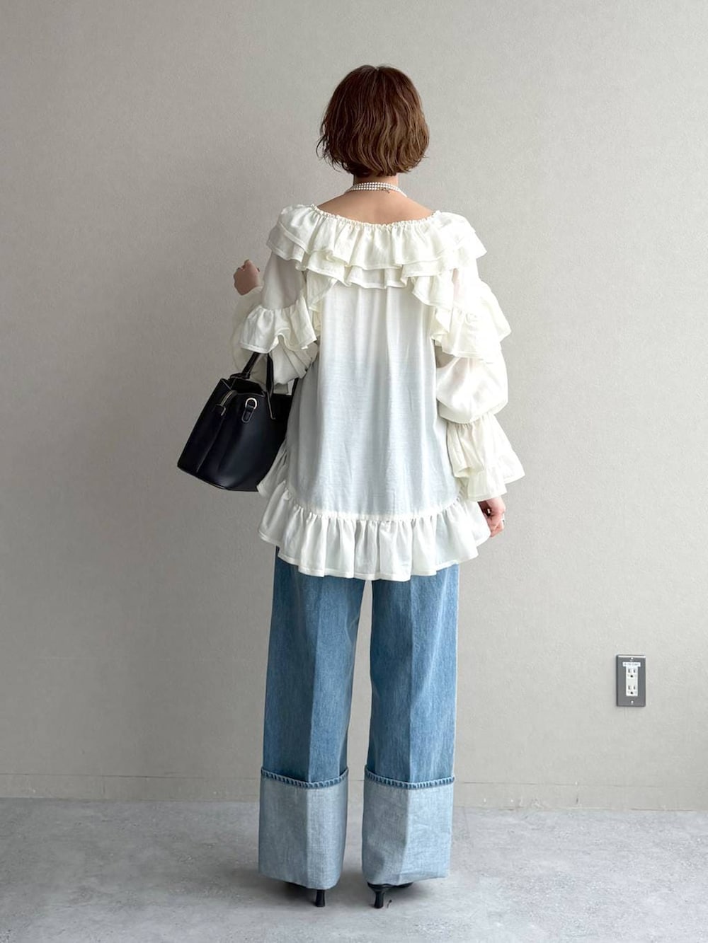 ブラック系のサンダル、ベージュ系のトレンチコート、ブルー系のデニムパンツを着用したレディースの春コーディネートの7枚目の写真