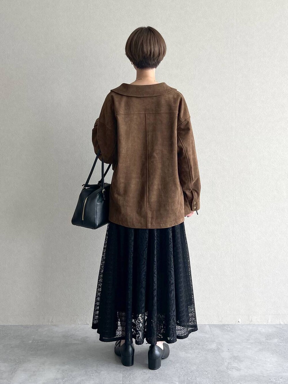 ブラック系のハンドバッグ、ブラック系のワンピース、ブラック系のドレスシューズを着用したレディースの秋コーディネートの3枚目の写真