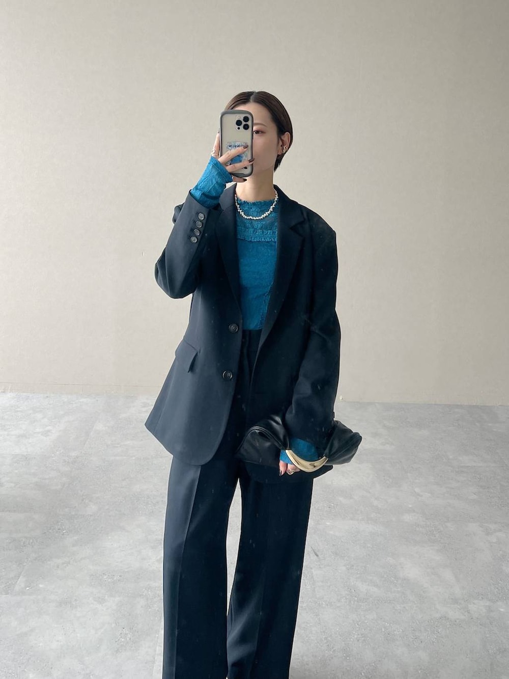 ブラック系のハンドバッグ、ブルー系のTシャツ/カットソー、ブルー系のスラックスを着用したレディースの秋コーディネートの4枚目の写真