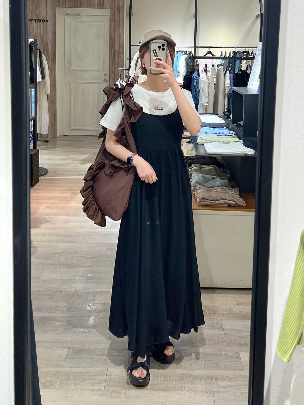 ブラック系のサンダル、ホワイト系のTシャツ/カットソー、ブラック系のワンピースを着用したレディースの春コーディネートの4枚目の写真