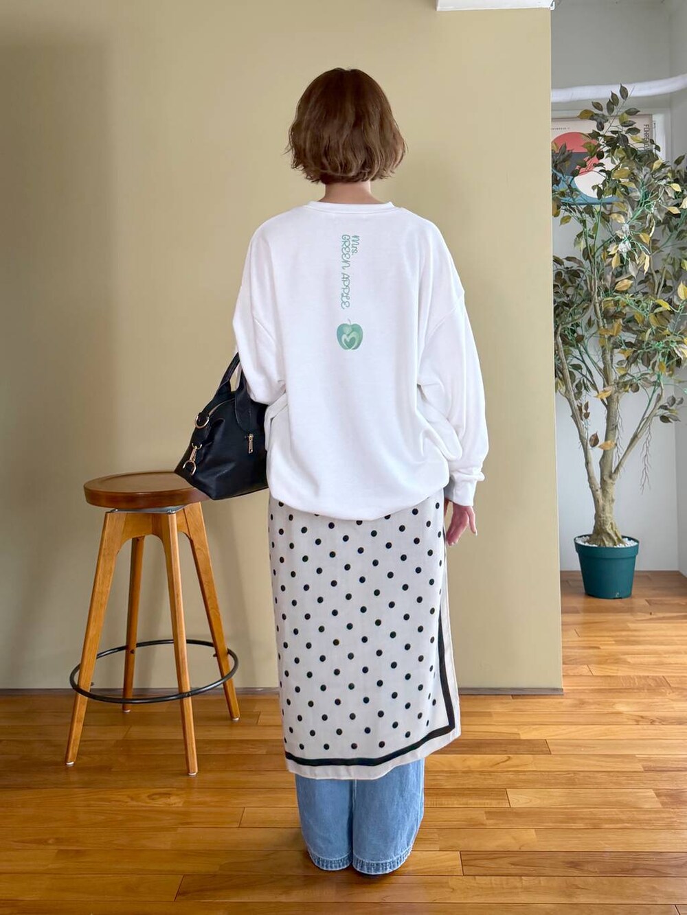 ブラック系のボストンバッグ、ブルー系のデニムパンツ、ブラック系のパンプスを着用したレディースの春コーディネートの7枚目の写真