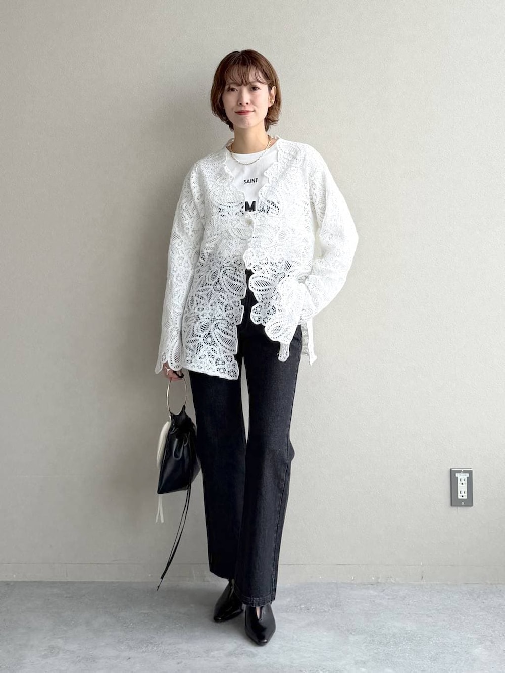 ブラック系のデニムパンツ、ブラック系のサンダル、ブラウン系のブルゾンを着用したレディースの冬コーディネートの5枚目の写真