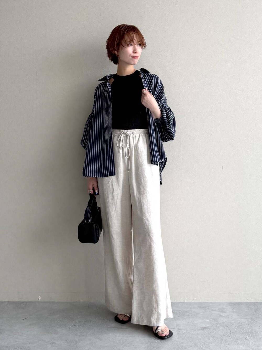ブラック系のニット/セーター、ベージュ系のその他パンツ、ブラック系のショルダーバッグを着用したレディースの夏コーディネートの7枚目の写真
