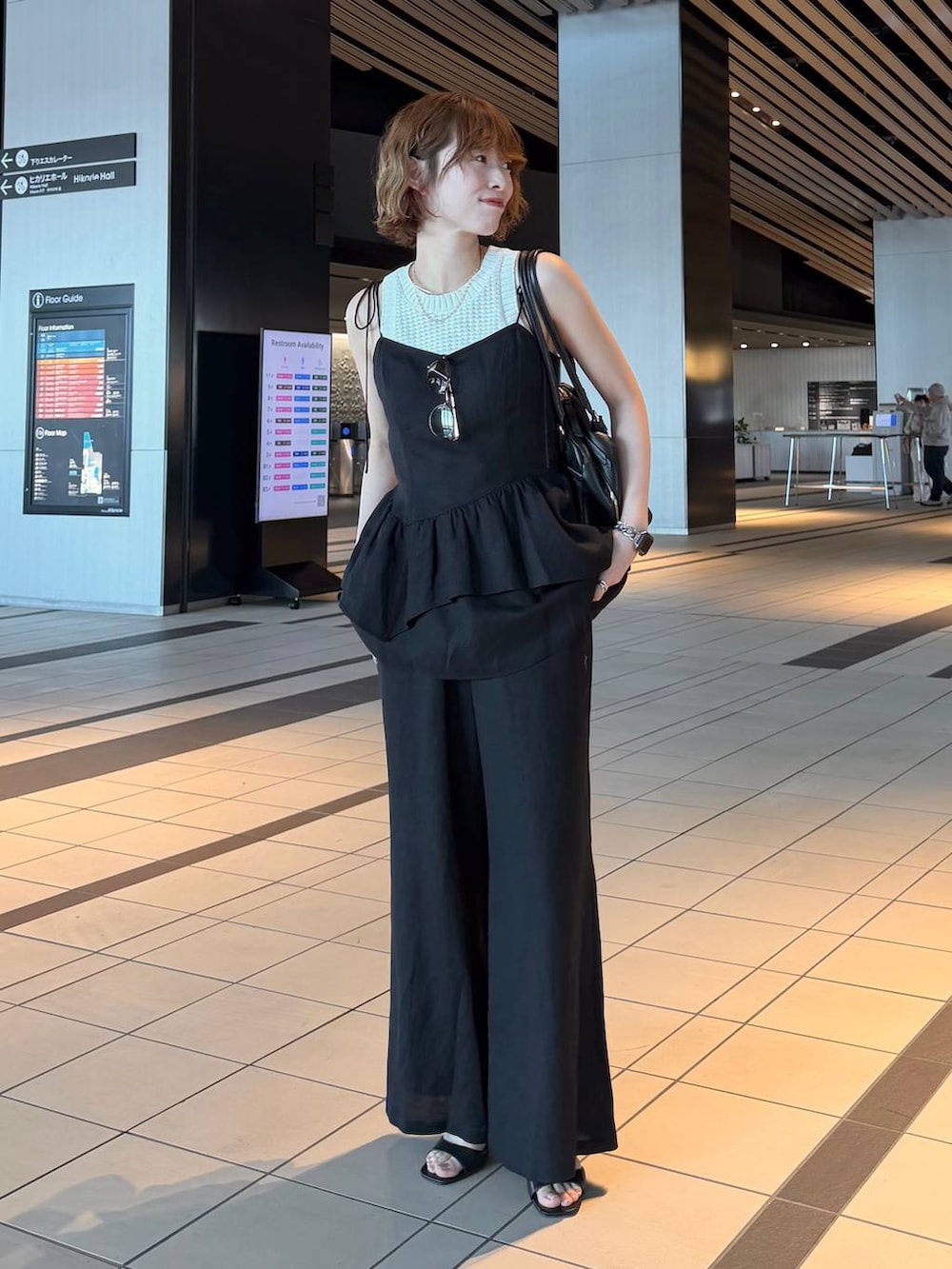 ブラック系のハンドバッグ、ブラック系のサンダル、ブラック系のシャツ/ブラウスを着用したレディースの春コーディネートの6枚目の写真