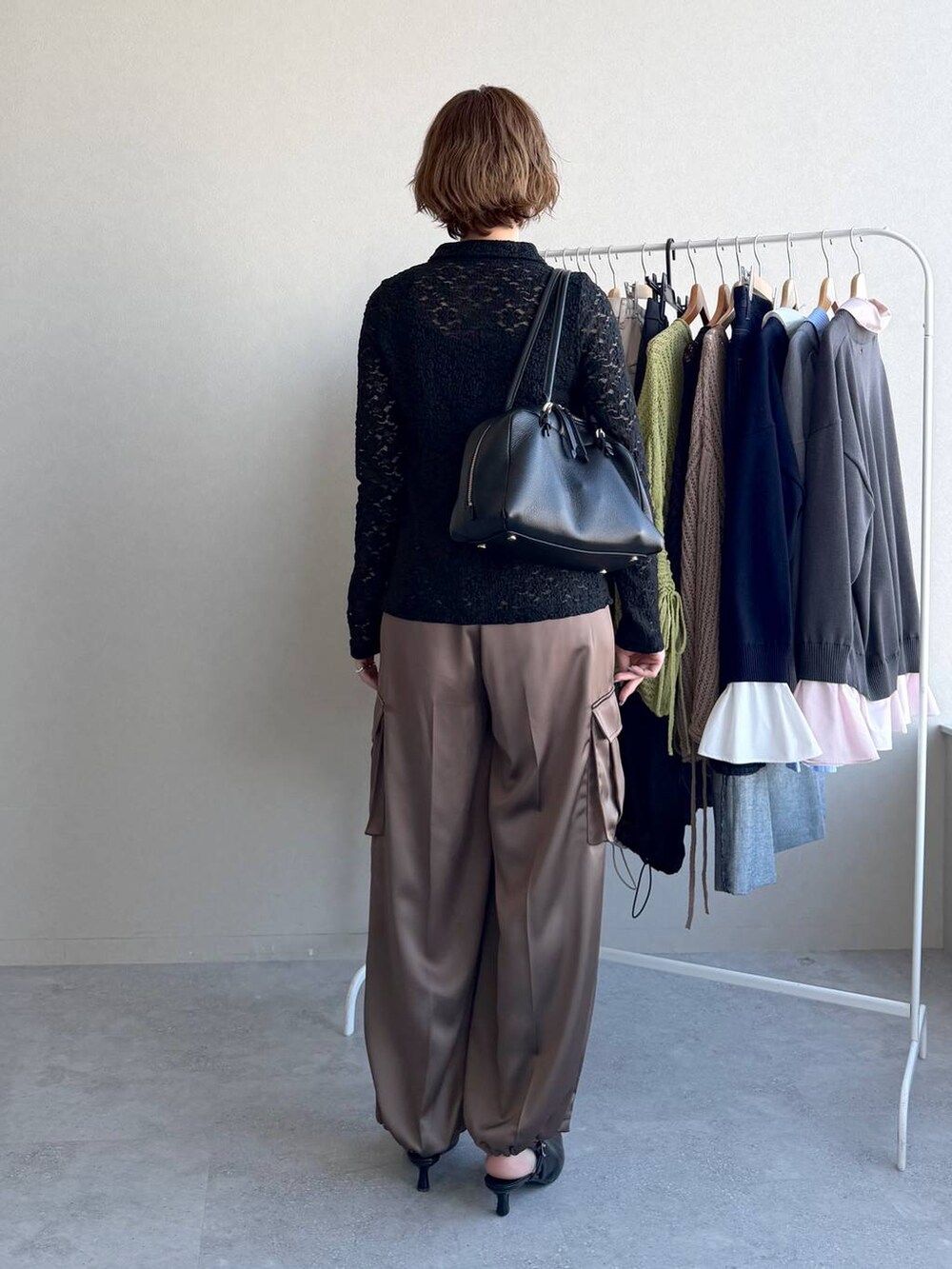 ブラック系のハンドバッグ、ブラック系のサンダル、ブラウン系のその他パンツを着用したレディースの冬コーディネートの3枚目の写真