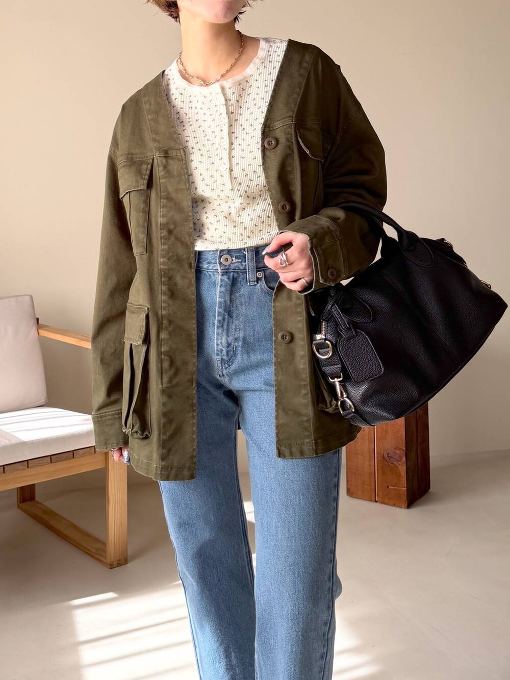 ブラック系のボストンバッグ、ブルー系のデニムパンツ、ブラック系のサンダルを着用したレディースの冬コーディネートの4枚目の写真