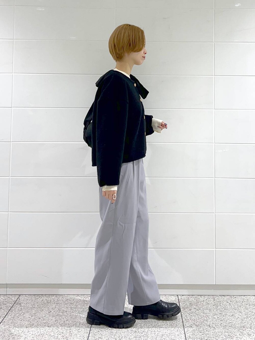 ブラック系のショルダーバッグ、ブラック系のブーツ、ホワイト系のニット/セーターを着用したレディースの冬コーディネートの2枚目の写真