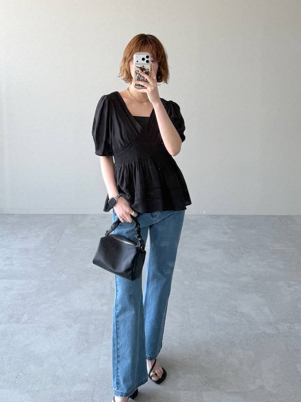 ブルー系のデニムパンツ、ブラック系のキャミソール、ブラック系のショルダーバッグを着用したレディースの春コーディネートの5枚目の写真