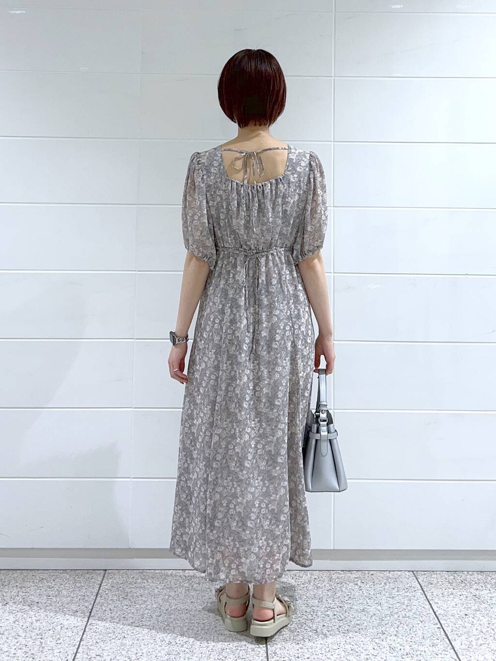 グレー系のサンダル、グレー系のワンピース、シルバー系のショルダーバッグを着用したレディースの夏コーディネートの4枚目の写真