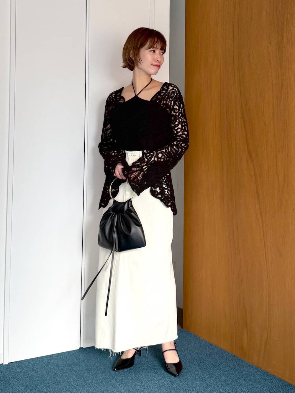 ブラック系のサンダル、ブラック系のハンドバッグ、ブラック系のシャツ/ブラウスを着用したレディースの春コーディネートの5枚目の写真