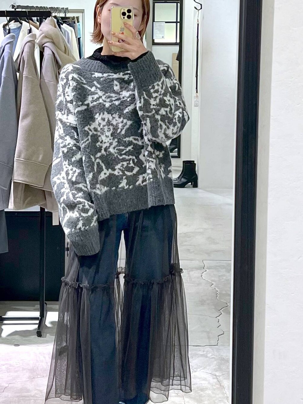 ブルー系のデニムパンツ、ブラック系のハンドバッグ、ブラック系のブーツを着用したレディースの冬コーディネートの4枚目の写真