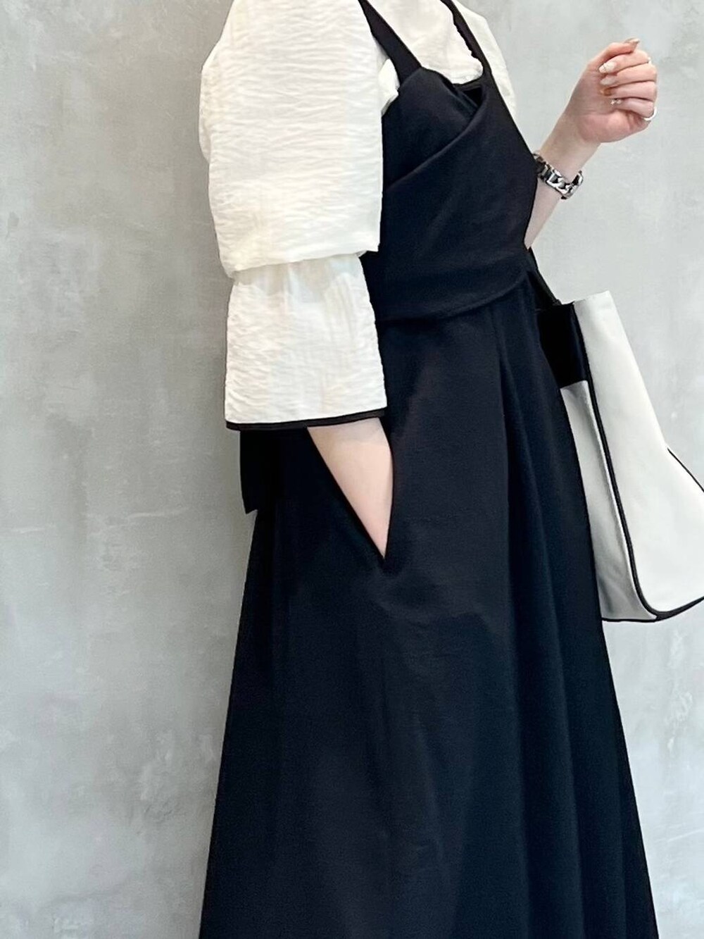 ブラック系のトートバッグ、ホワイト系のシャツ/ブラウス、ブラック系のパンプスを着用したレディースの春コーディネートの4枚目の写真