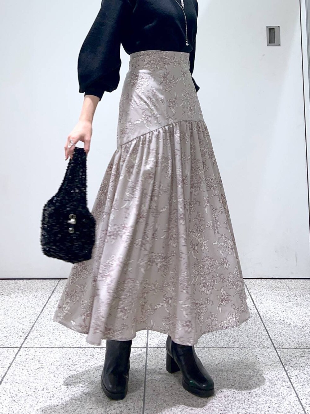 ブラック系のブーツ、ブラック系のニット/セーター、ブラック系のハンドバッグを着用したレディースの冬コーディネートの7枚目の写真