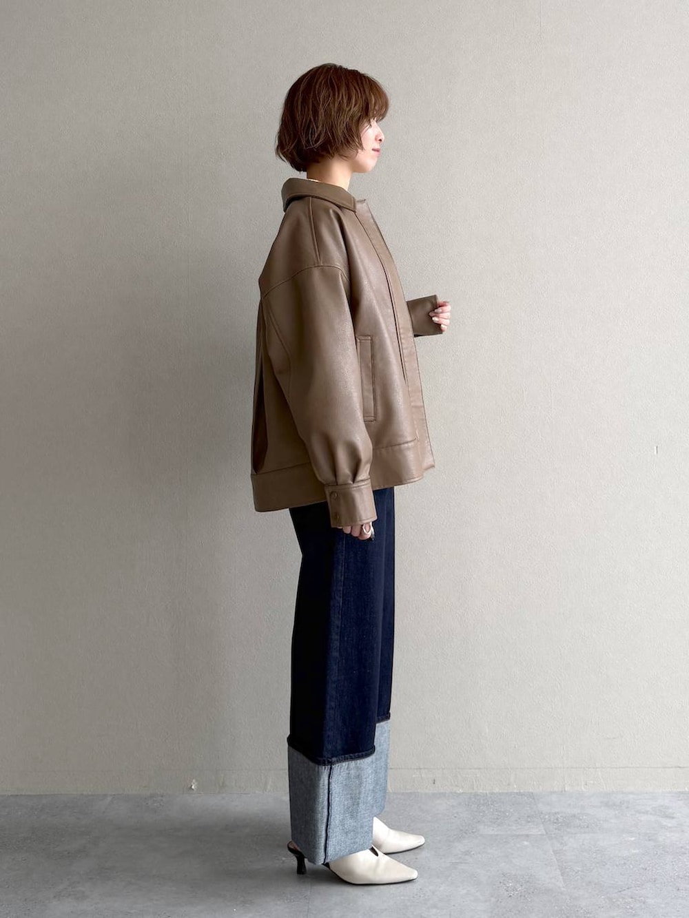 ホワイト系のサンダル、ブラウン系のブルゾン、イエロー系のカーディガン/ボレロを着用したレディースの春コーディネートの2枚目の写真