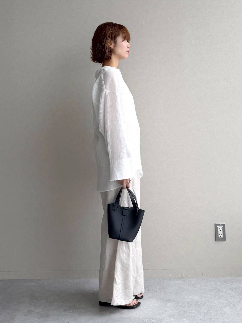 ホワイト系のシャツ/ブラウス、ベージュ系のその他パンツ、ブラック系のショルダーバッグを着用したレディースの春コーディネートの2枚目の写真