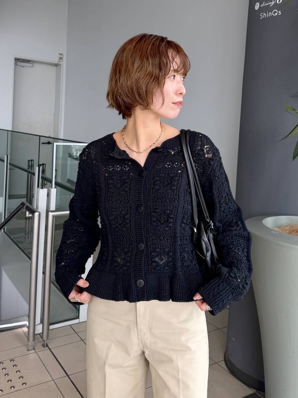 ブラック系のハンドバッグ、ブラック系のローファー、ブラック系のカーディガン/ボレロを着用したレディースの冬コーディネートの4枚目の写真