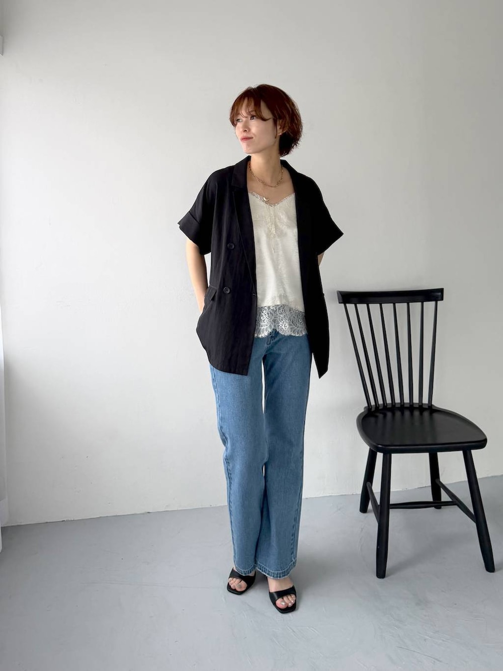 ブルー系のデニムパンツ、ホワイト系のキャミソール、ブラック系のサンダルを着用したレディースの春コーディネートの3枚目の写真