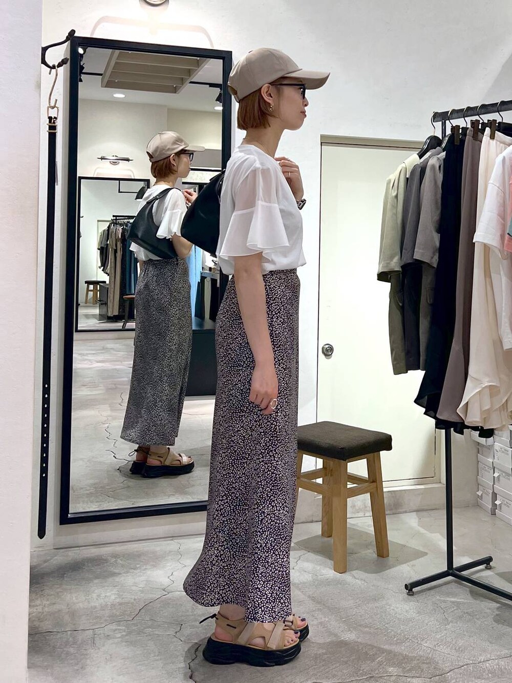 ベージュ系のサンダル、ホワイト系のTシャツ/カットソー、ブラック系のショルダーバッグを着用したレディースの夏コーディネートの2枚目の写真