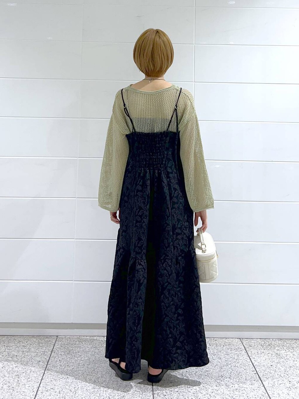 ブラック系のサンダル、ブラック系のワンピース、ホワイト系のショルダーバッグを着用したレディースの夏コーディネートの3枚目の写真