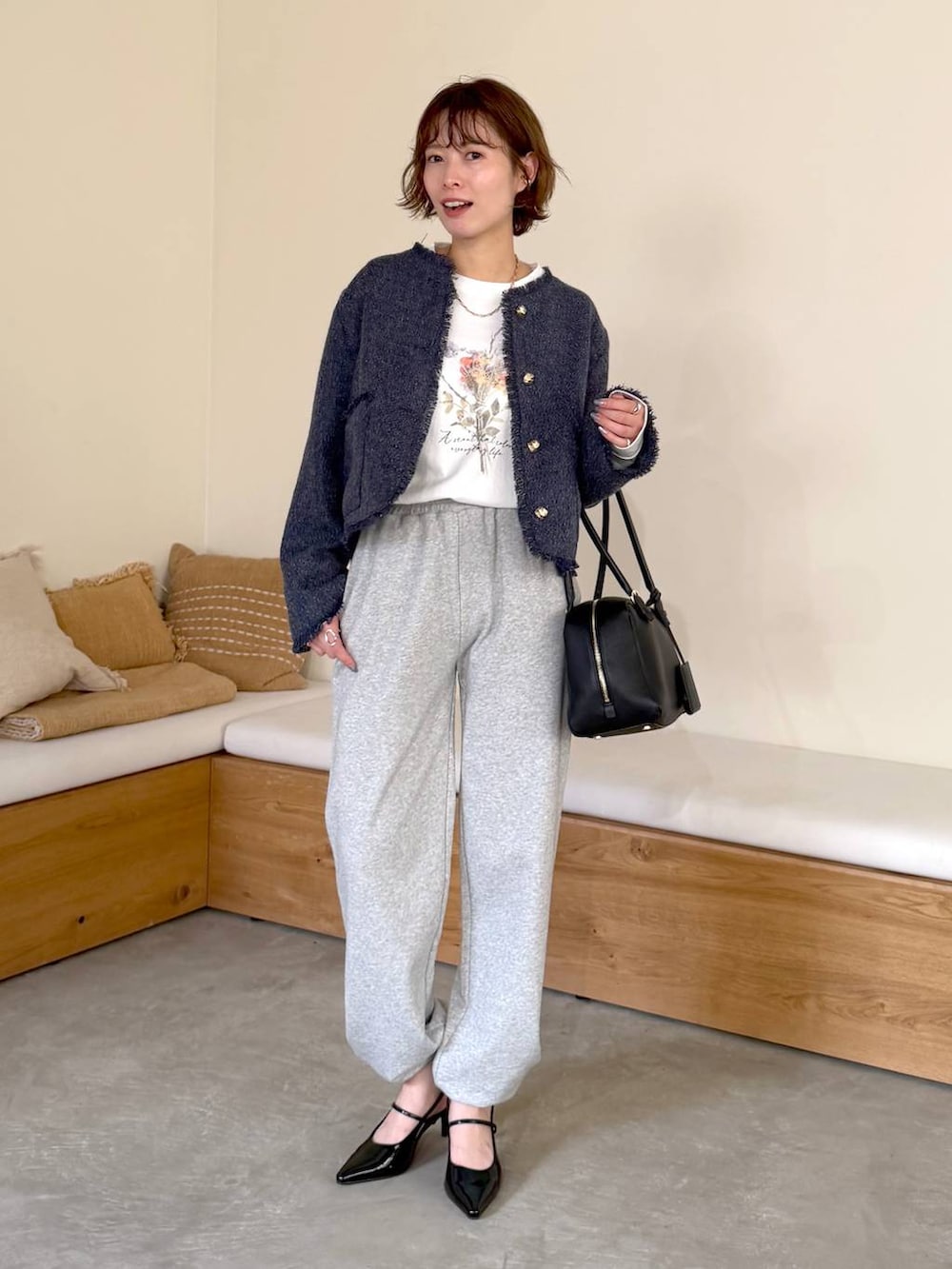 ブラック系のハンドバッグ、ブラック系のサンダル、ホワイト系のTシャツ/カットソーを着用したレディースの冬コーディネートの5枚目の写真