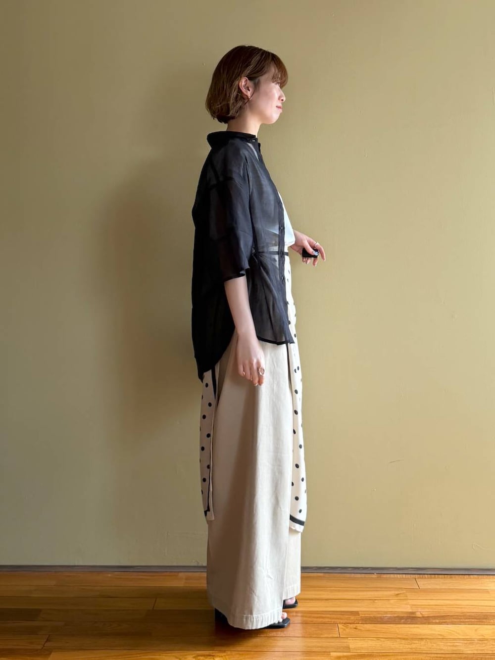 ブラック系のサンダル、ブラック系のシャツ/ブラウス、ベージュ系のチノパンツを着用したレディースの春コーディネートの2枚目の写真