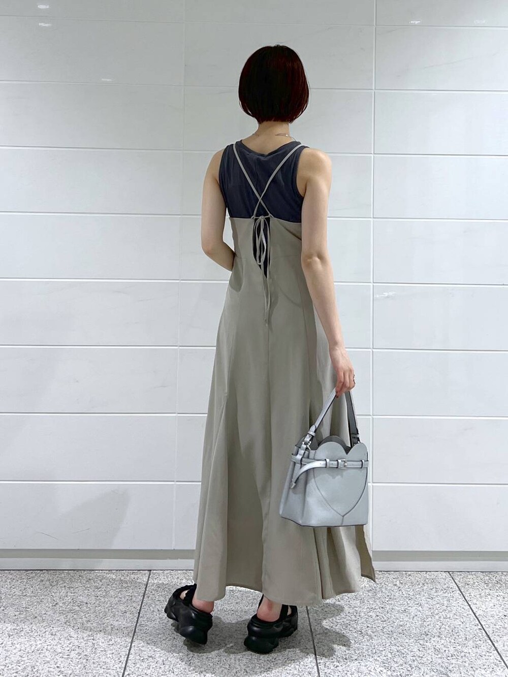 ブラック系のブルゾン、シルバー系のショルダーバッグ、ベージュ系のワンピースを着用したレディースの夏コーディネートの6枚目の写真