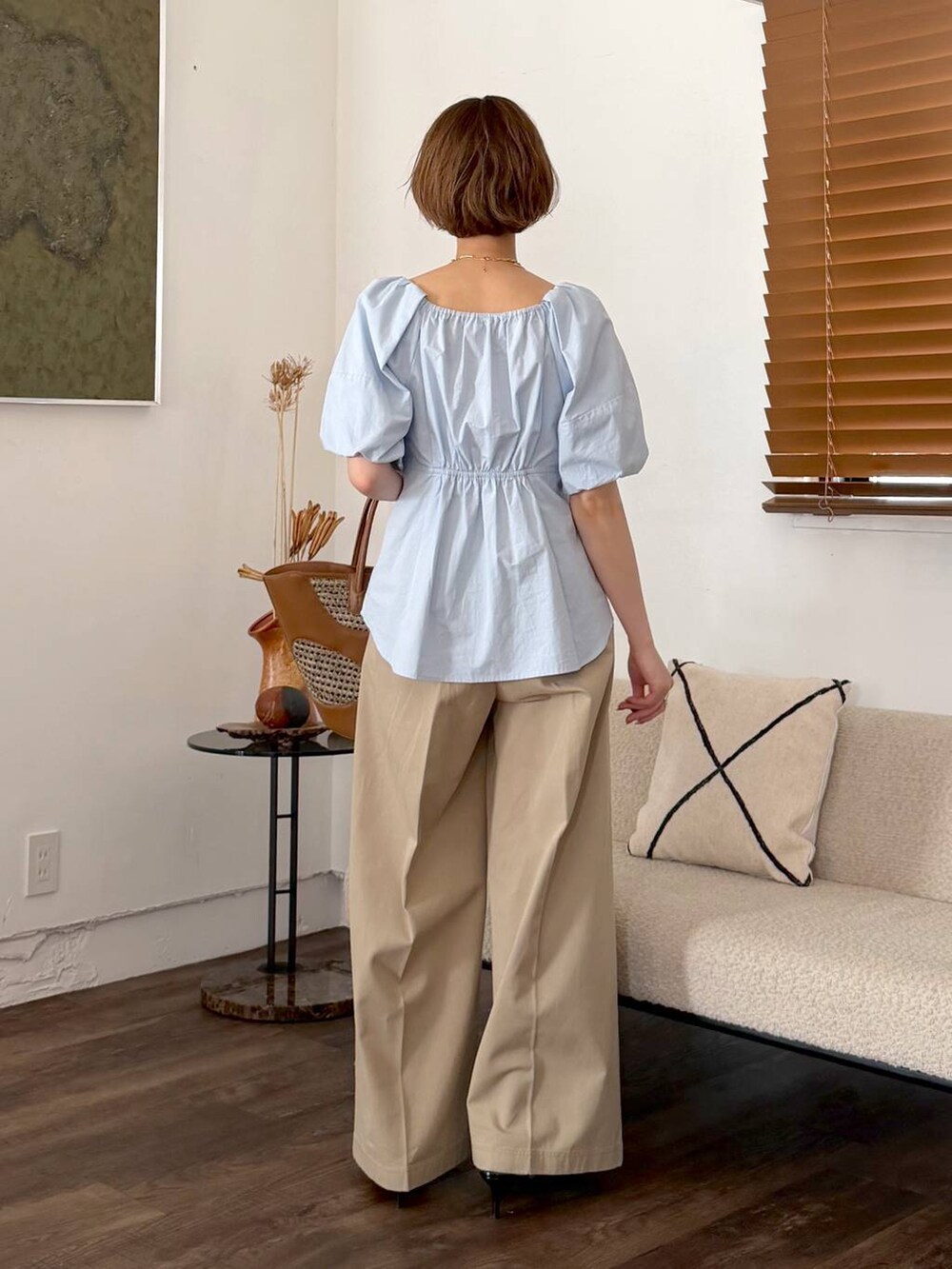 ブラウン系のトートバッグ、ブラック系のサンダル、ベージュ系のチノパンツを着用したレディースの春コーディネートの3枚目の写真