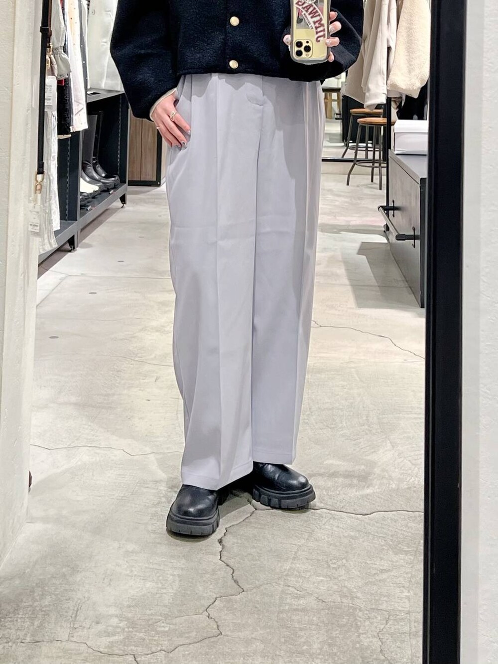 ブラック系のショルダーバッグ、ブラック系のブーツ、ホワイト系のニット/セーターを着用したレディースの冬コーディネートの6枚目の写真