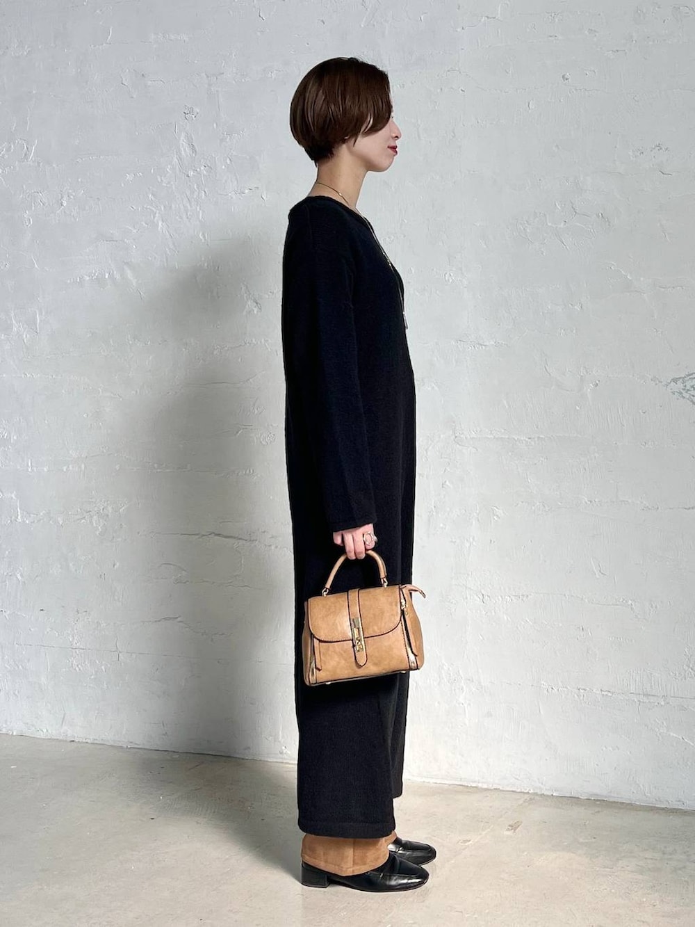 ブラック系のローファー、ブラウン系のスラックス、ブラウン系のショルダーバッグを着用したレディースの秋コーディネートの2枚目の写真