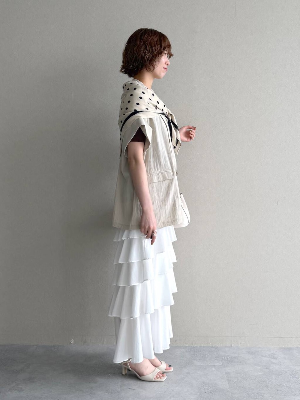 ホワイト系のサンダル、ブラウン系のTシャツ/カットソー、ホワイト系のスカートを着用したレディースの春コーディネートの2枚目の写真