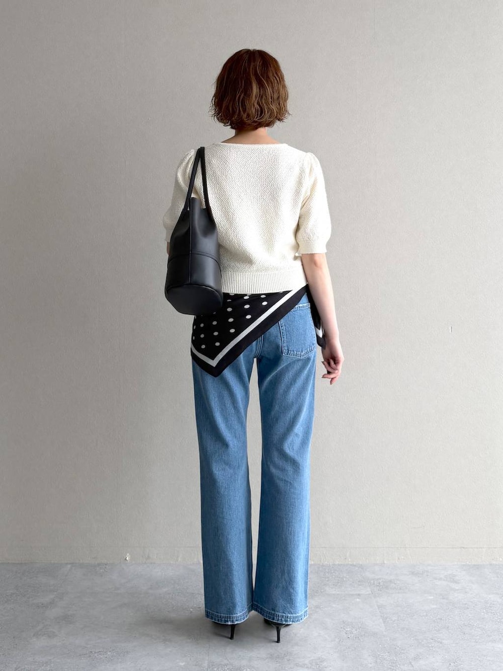 ホワイト系のカーディガン/ボレロ、ブルー系のデニムパンツ、ブラック系のサンダルを着用したレディースの春コーディネートの3枚目の写真