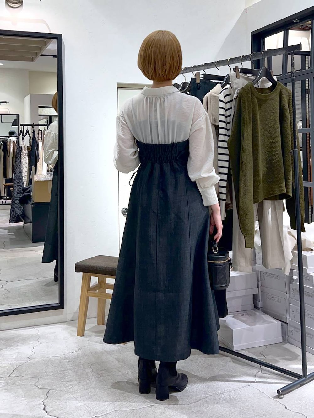 ブラック系のブーツ、グレー系のワンピース、ブラック系のショルダーバッグを着用したレディースの秋コーディネートの3枚目の写真