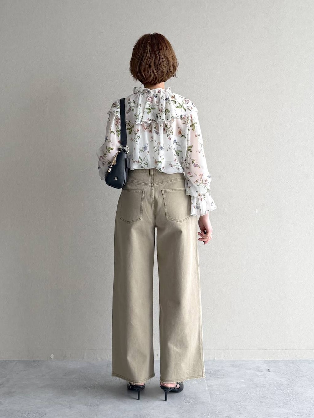 ブラック系のサンダル、ホワイト系のシャツ/ブラウス、ブラック系のショルダーバッグを着用したレディースの春コーディネートの3枚目の写真