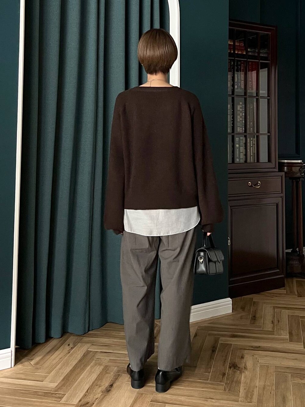 ブラウン系のニット/セーター、ブラック系のローファー、ホワイト系のTシャツ/カットソーを着用したレディースの秋コーディネートの3枚目の写真