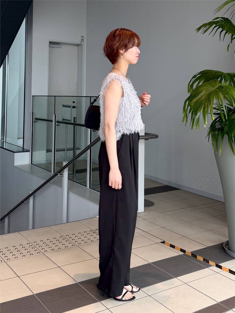 グレー系のベスト、ブラック系のその他パンツ、ブラック系のショルダーバッグを着用したレディースの夏コーディネートの2枚目の写真