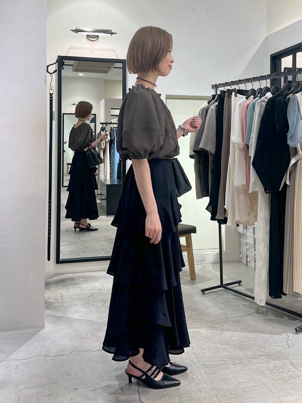 ブラック系のショルダーバッグ、ブラウン系のシャツ/ブラウス、ブラック系のスカートを着用したレディースの夏コーディネートの2枚目の写真