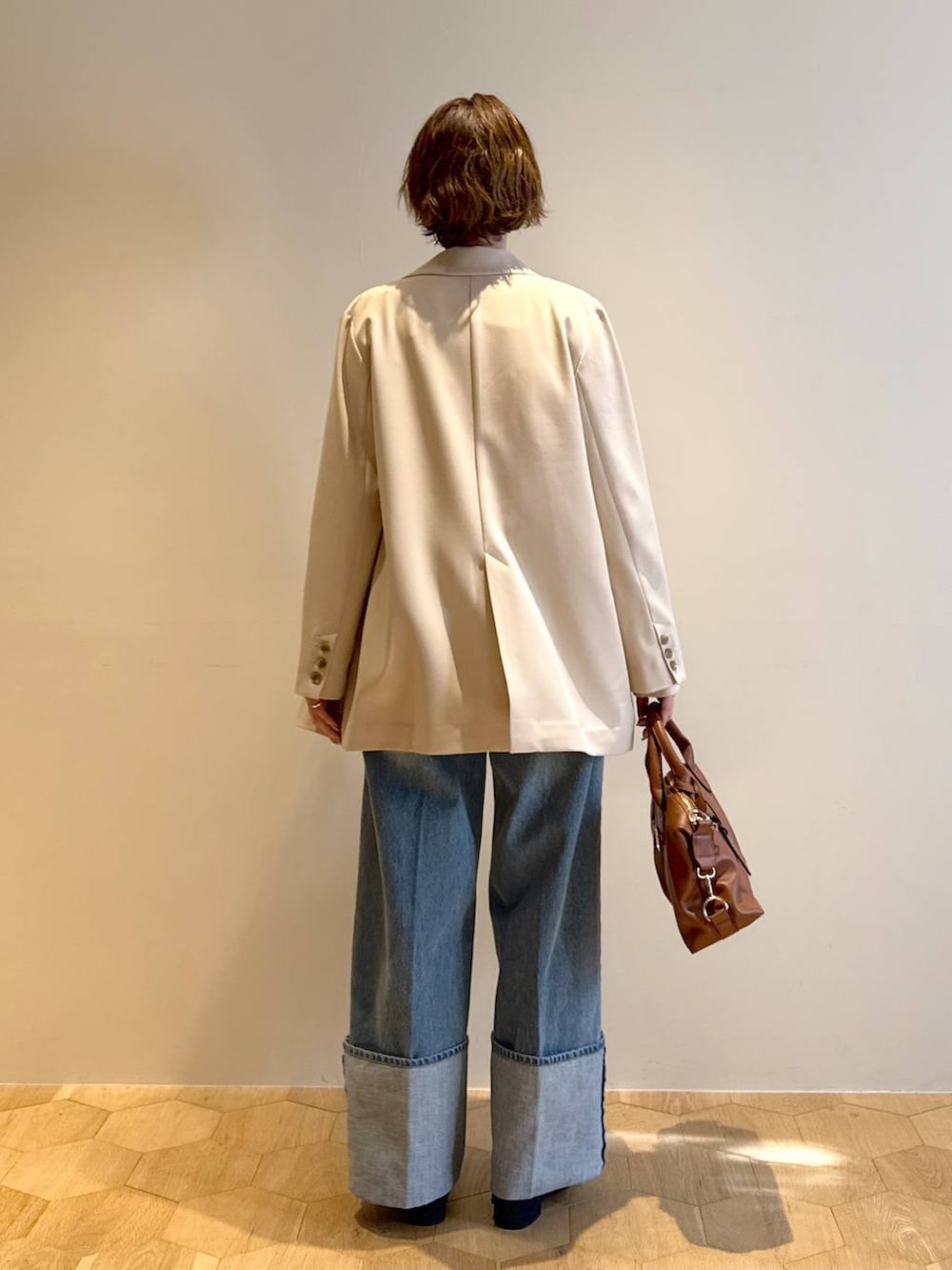 ブラウン系のボストンバッグ、ブルー系のパンプス、ホワイト系のキャミソールを着用したレディースの冬コーディネートの3枚目の写真