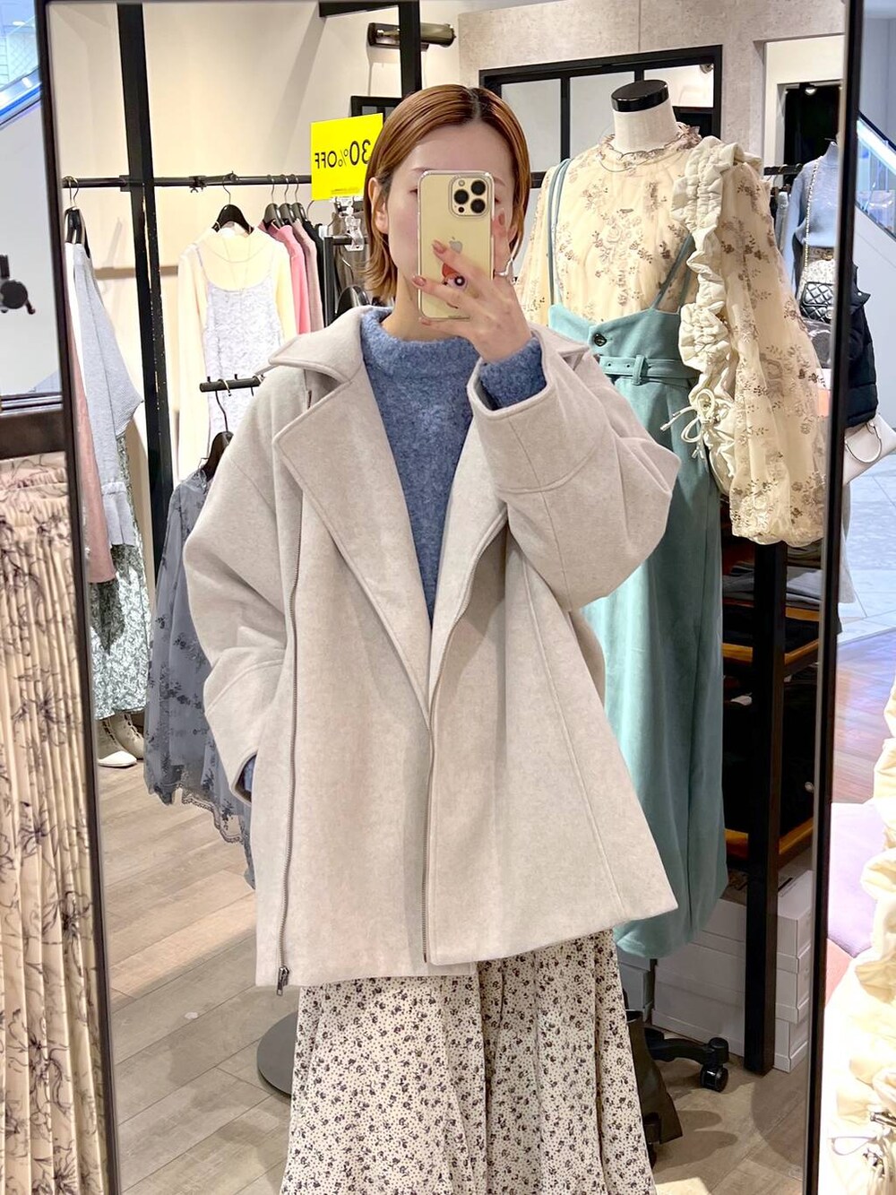 ブラック系のブーツ、ブルー系のニット/セーター、ホワイト系のスカートを着用したレディースの冬コーディネートの8枚目の写真