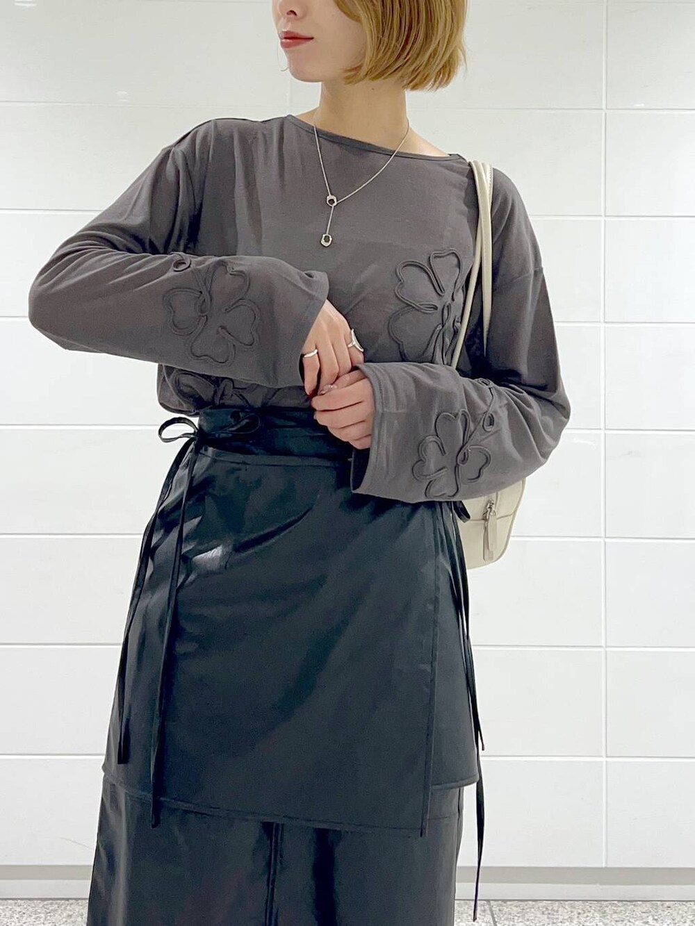 ブラック系のブーツ、グレー系のTシャツ/カットソー、ブラック系のスカートを着用したレディースの秋コーディネートの5枚目の写真