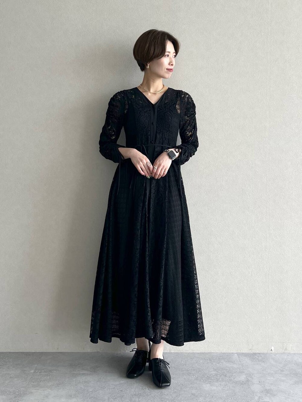 ブラック系のハンドバッグ、ブラック系のワンピース、ブラック系のドレスシューズを着用したレディースの秋コーディネートの6枚目の写真